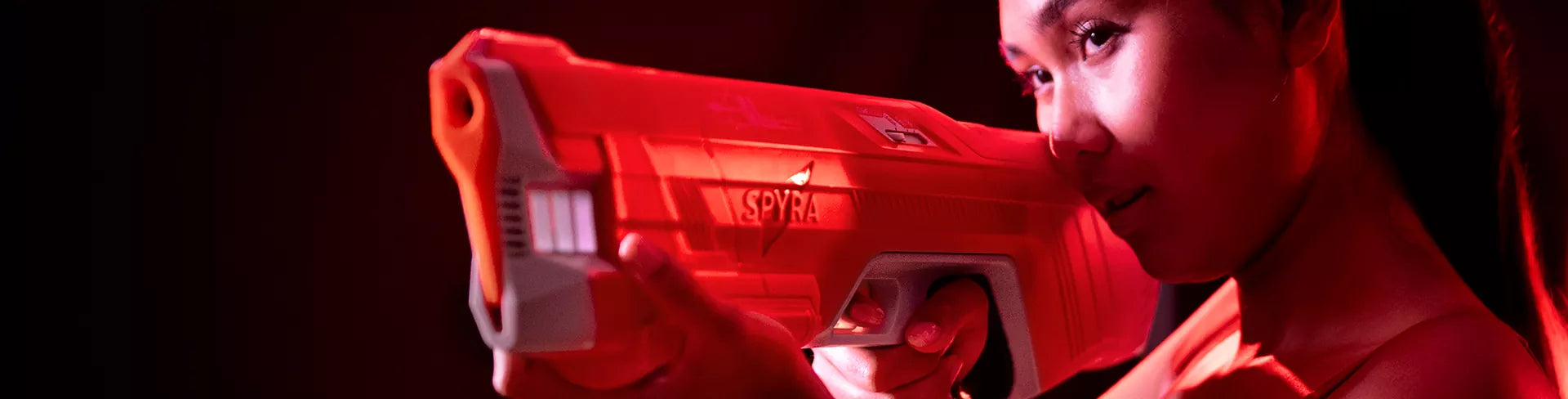 Girl using an electric Spyra water gun in red